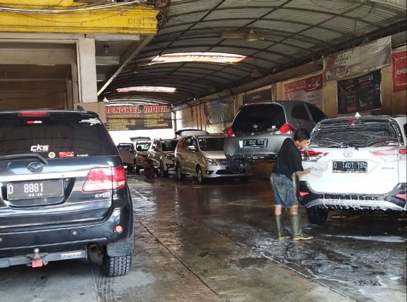 Suasana area cuci Sinar Surya Auto Care dengan beberapa mobil pelanggan